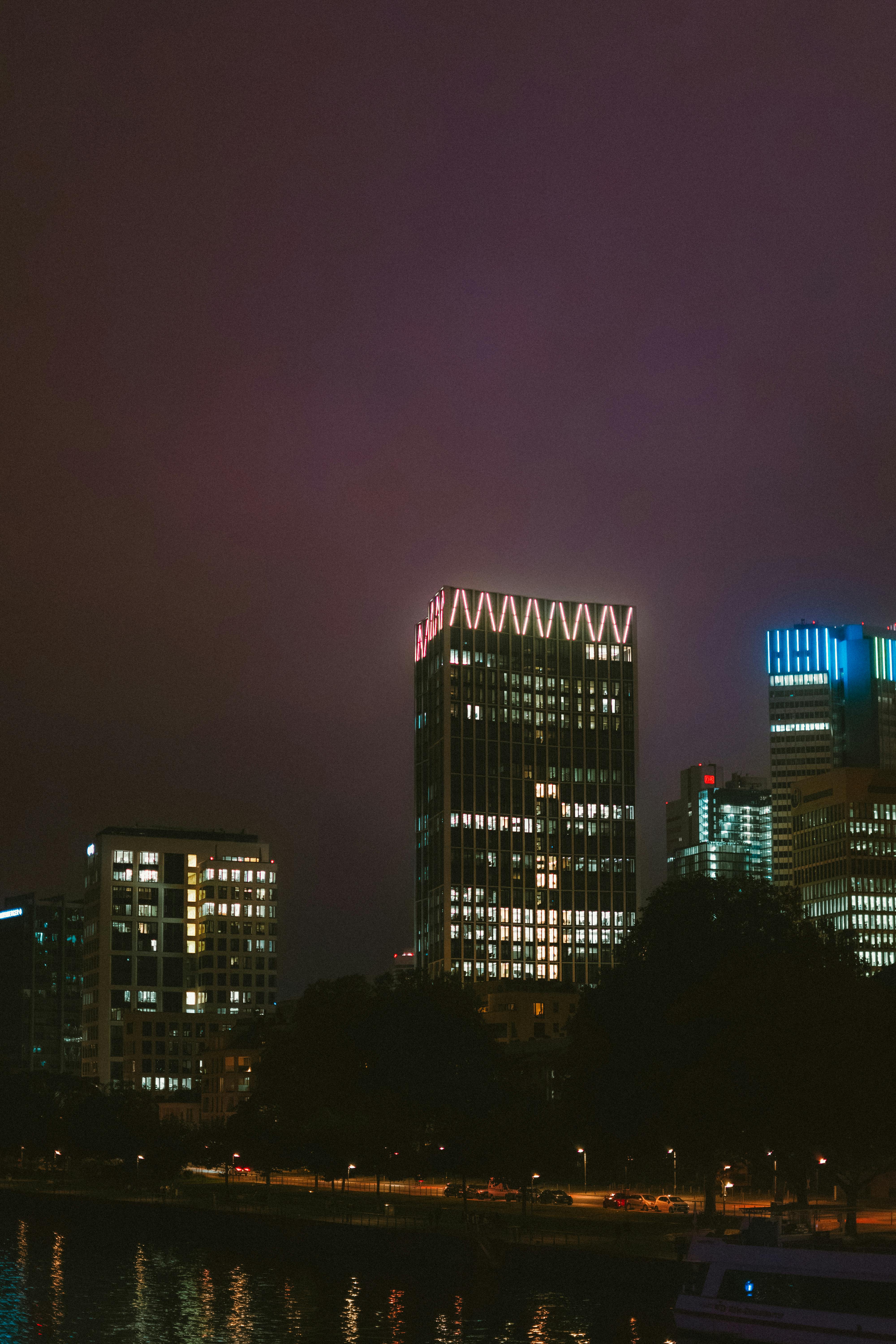 Gratis Splendida vista notturna del paesaggio urbano di Francoforte, con i grattacieli illuminati che si riflettono sul fiume. Foto a disposizione