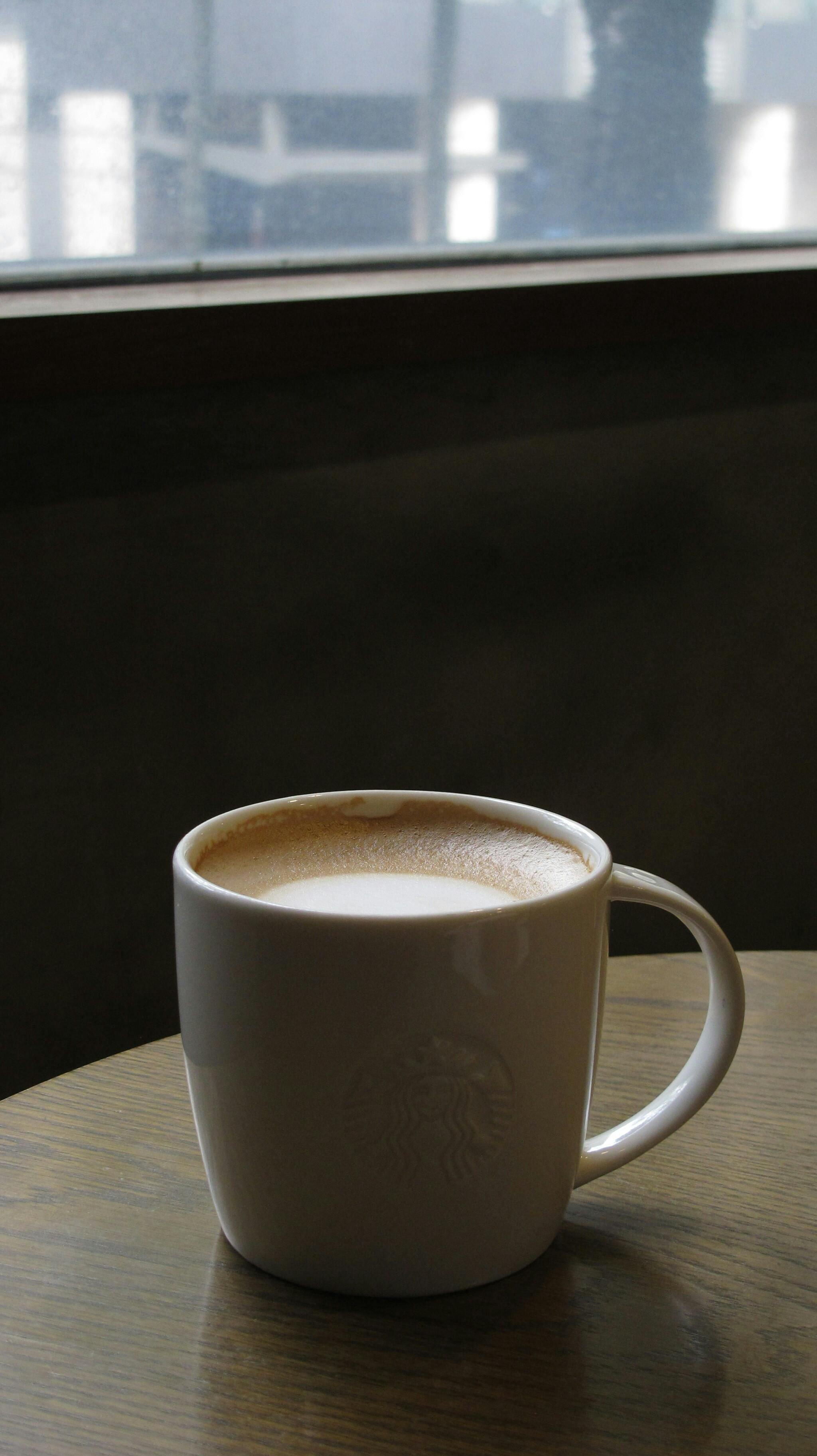 Δωρεάν Μια ζεστή κούπα καφέ τοποθετημένη σε ένα τραπέζι δίπλα σε ένα παράθυρο με φυσικό φως να μπαίνει μέσα. Φωτογραφία από στοκ φωτογραφιών