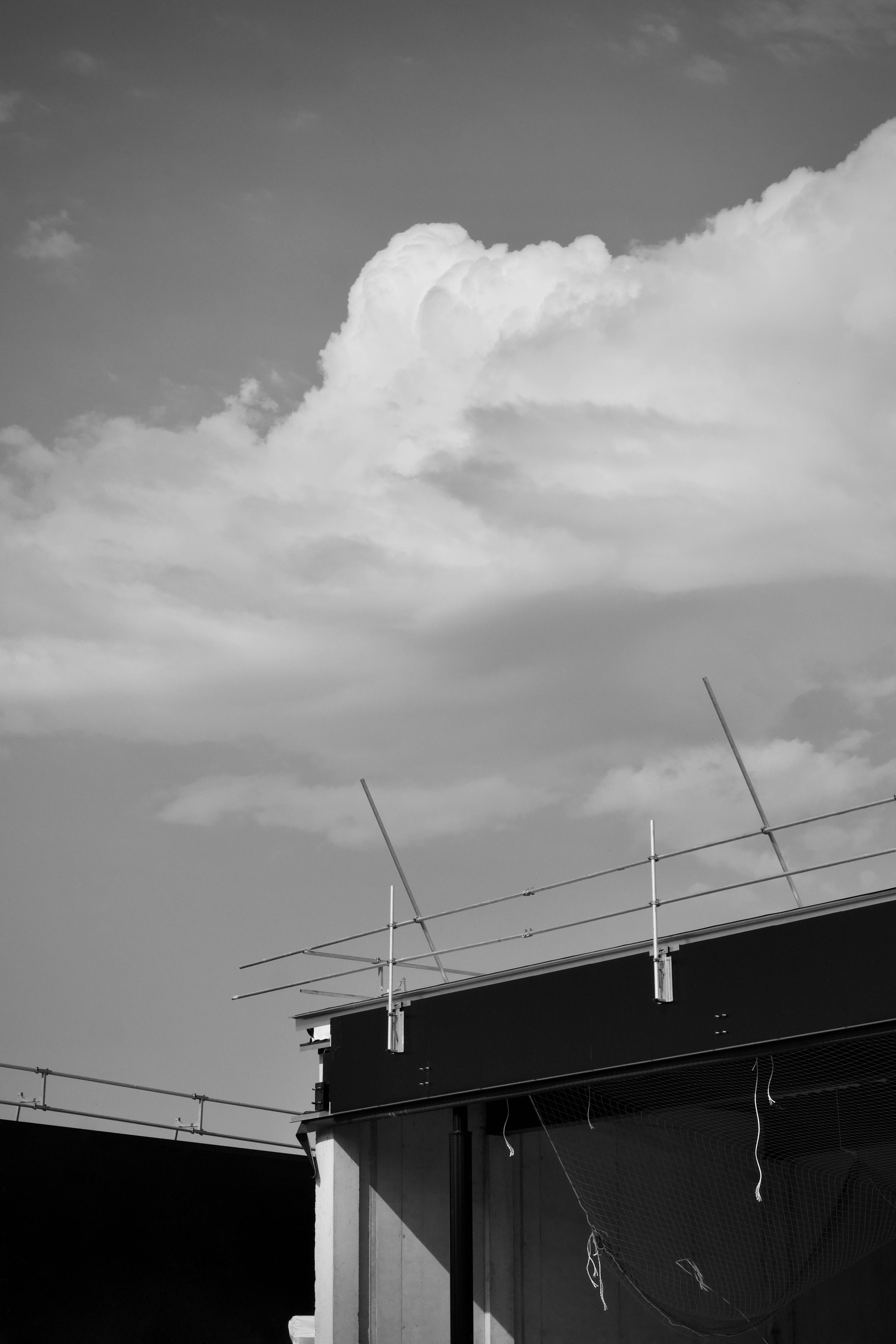 Free Black and white image of modern architecture with cloud formations. Stock Photo