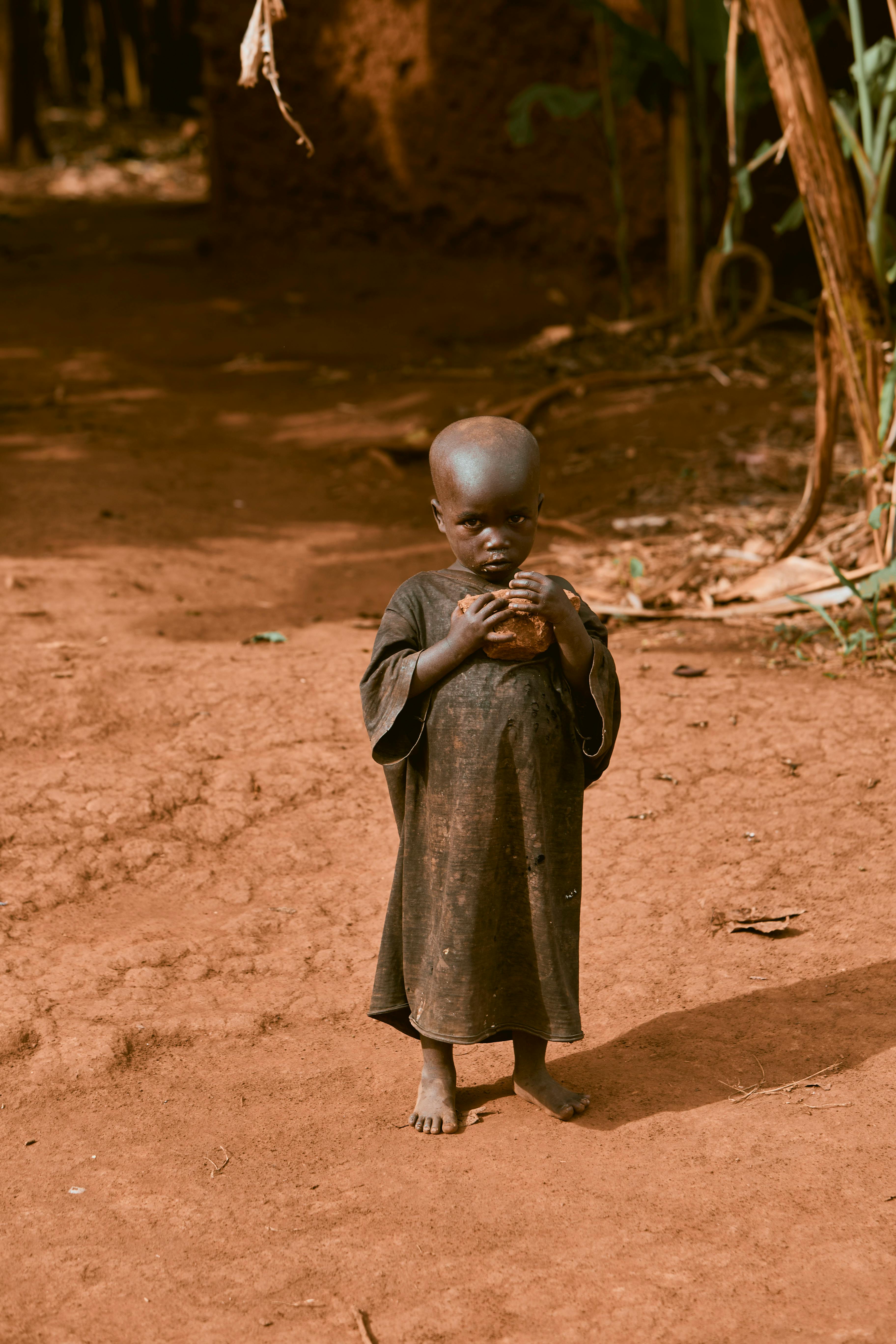 Bezpłatne Małe dziecko stoi boso na polnej ścieżce na wsi, w świetle dziennym. Zdjęcie z galerii