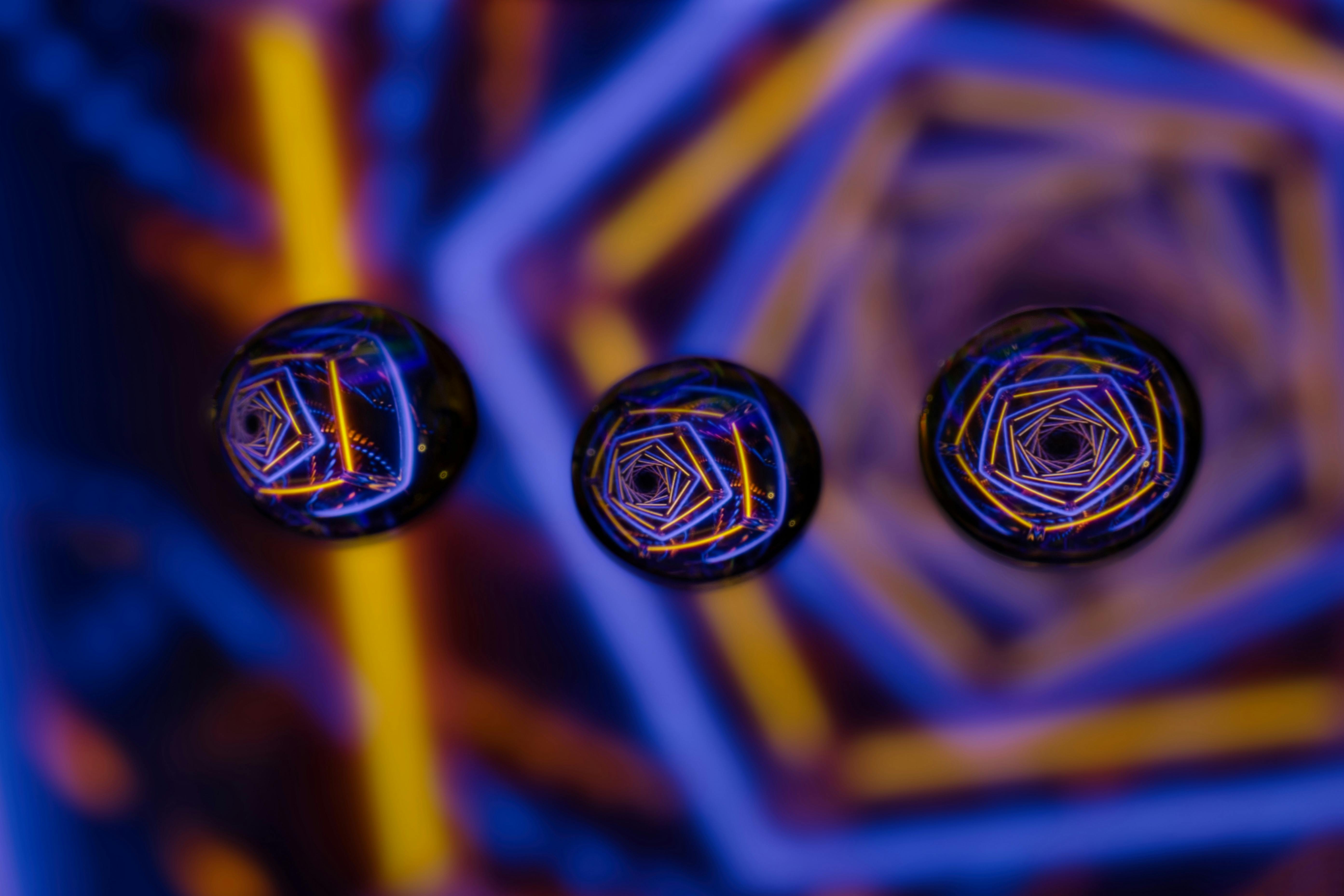 Free Close-up shot of water droplets reflecting vibrant geometric patterns, creating an abstract artistic effect. Stock Photo