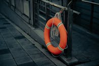 Orange Life Preserver Ring on Urban Pathway