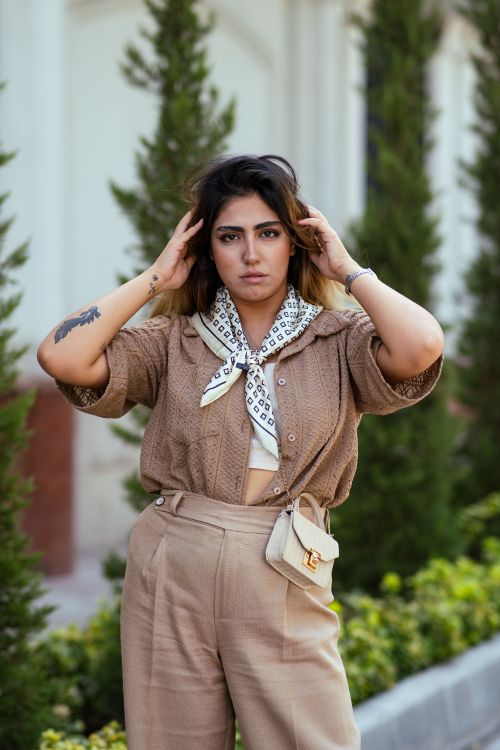 Free Stylish woman posing in a garden setting in Tehran, Iran. Stock Photo