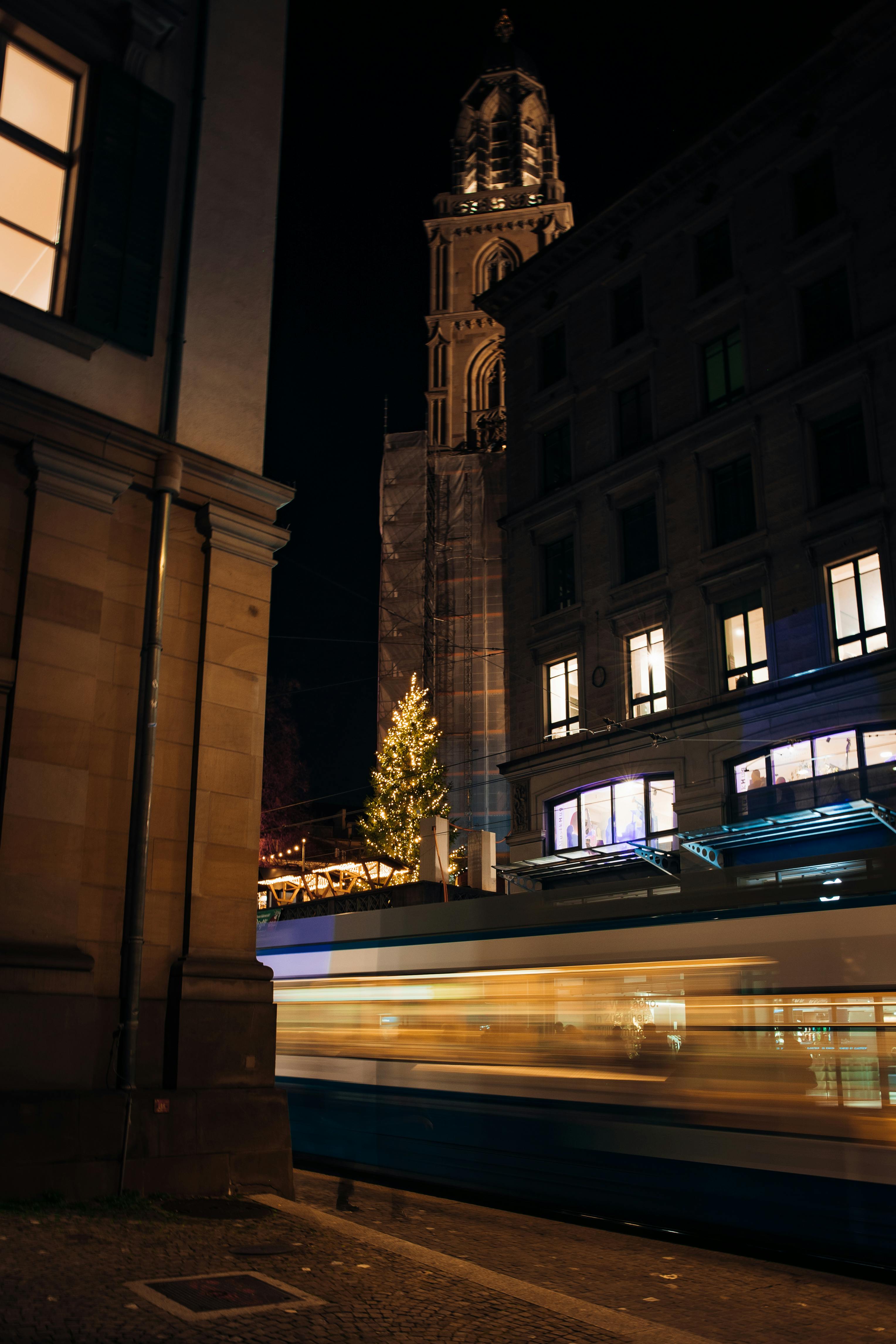 Δωρεάν Νυχτερινή άποψη ενός τραμ στη Ζυρίχη με την εκκλησία Fraumünster και τα χριστουγεννιάτικα φώτα. Φωτογραφία από στοκ φωτογραφιών