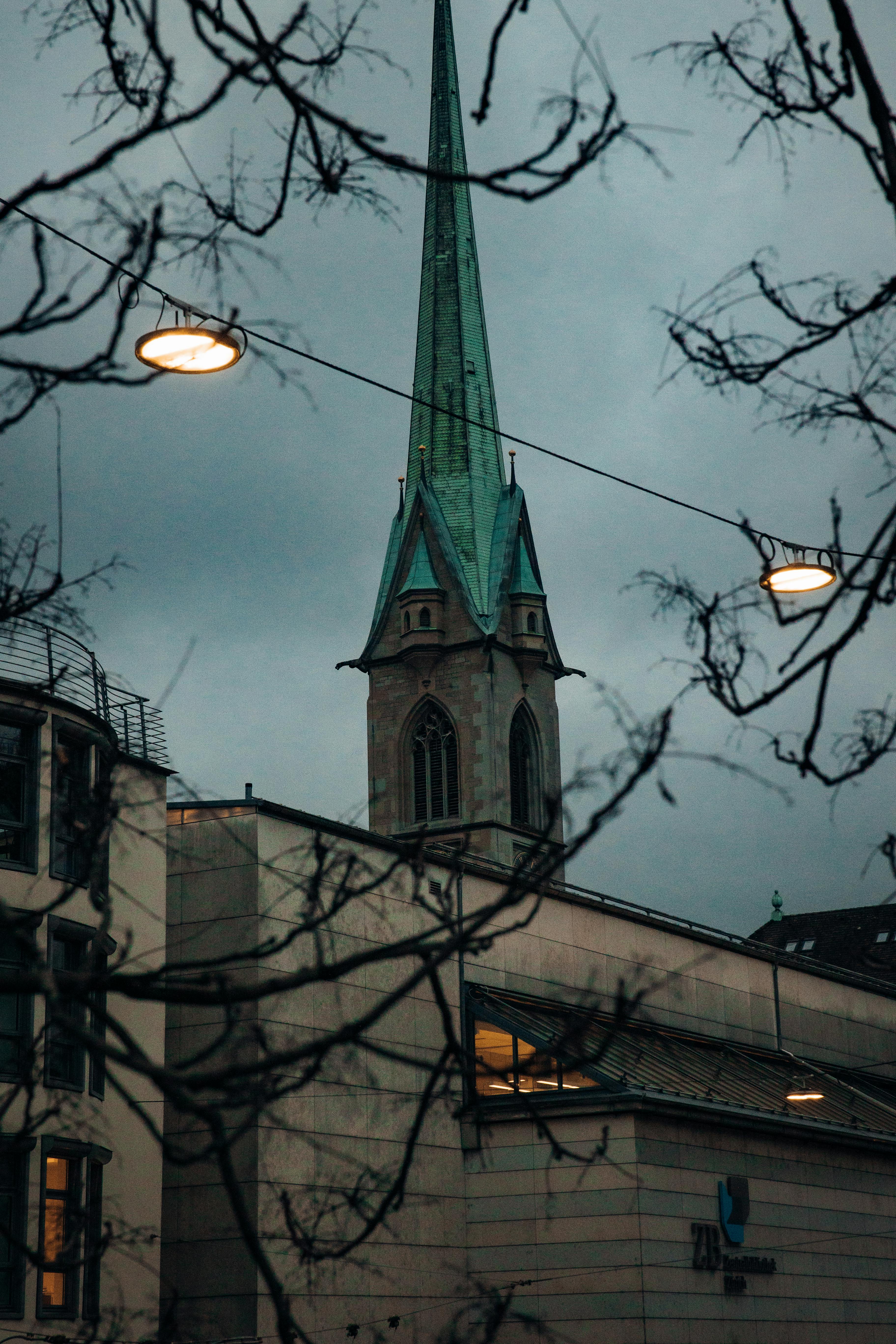 бесплатная Вид на церковную башню в Цюрихе, вырисовывающуюся на фоне впечатляющего вечернего неба. Стоковое фото