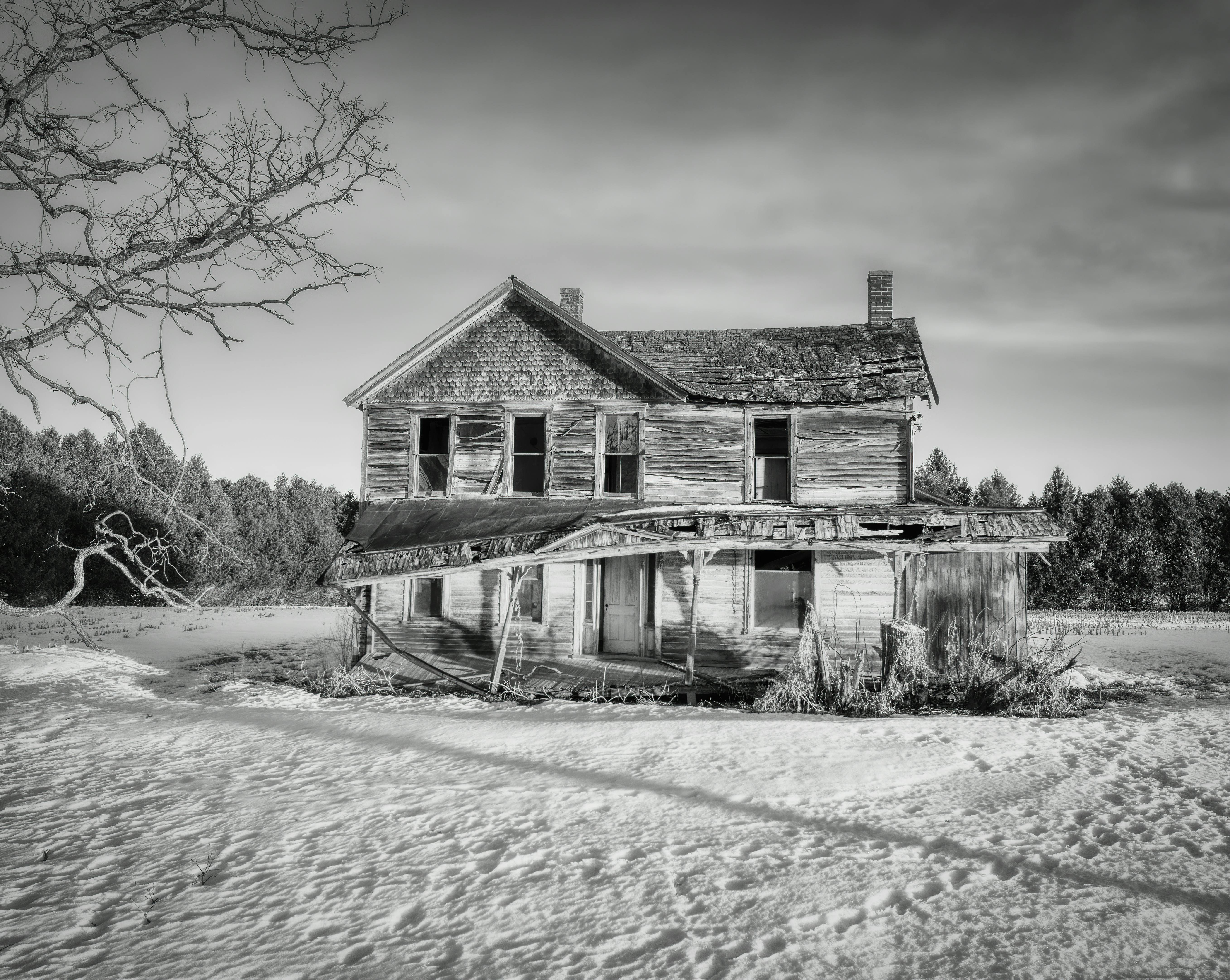 Kostenlos Eine Schwarz-Weiß-Aufnahme eines verlassenen Bauernhauses im verschneiten West Albany, Minnesota. Stock-Foto