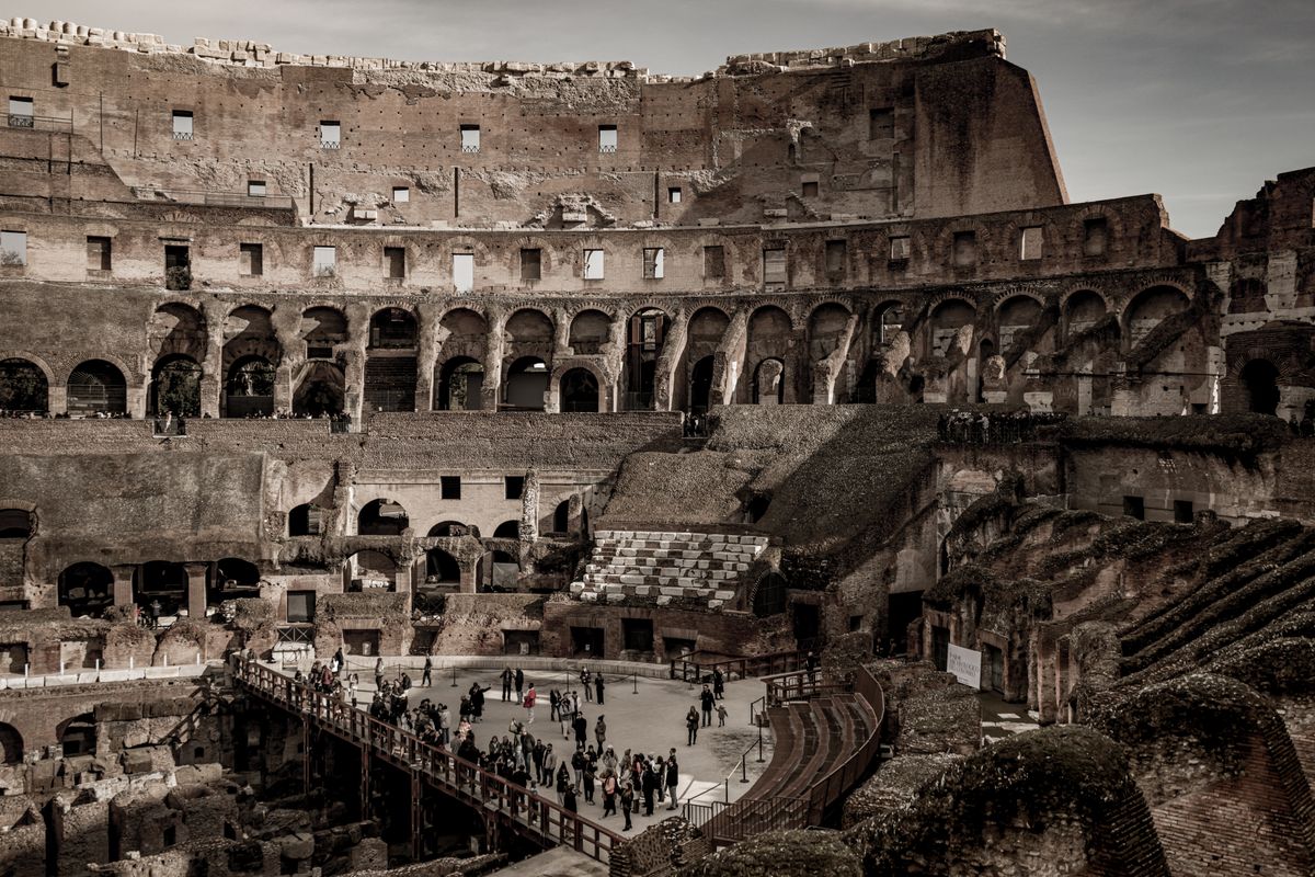Interiorul Colosseumului din Roma, cu arena descoperită și turiști printre ruine