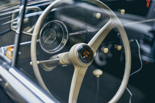 Close-up of a vintage car steering wheel with dashboard details, capturing a classic automotive feel.