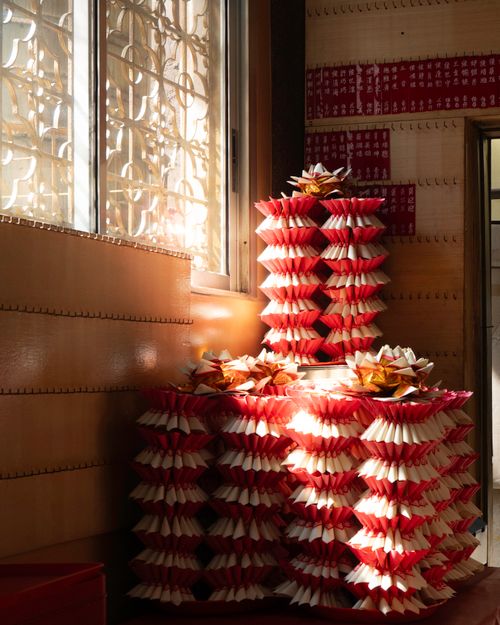 Free Stacks of decorative red and white paper in traditional interior setting with sunlight. Stock Photo
