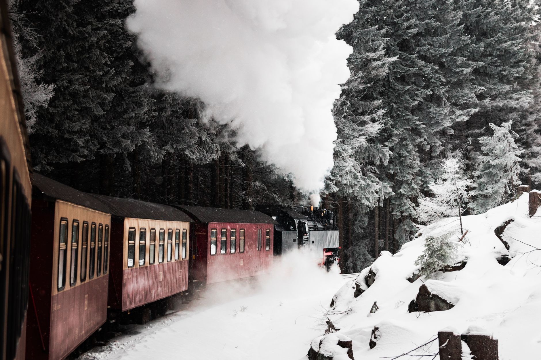 A picturesque steam train journeying through a snow-covered forest landscape, evoking adventure.