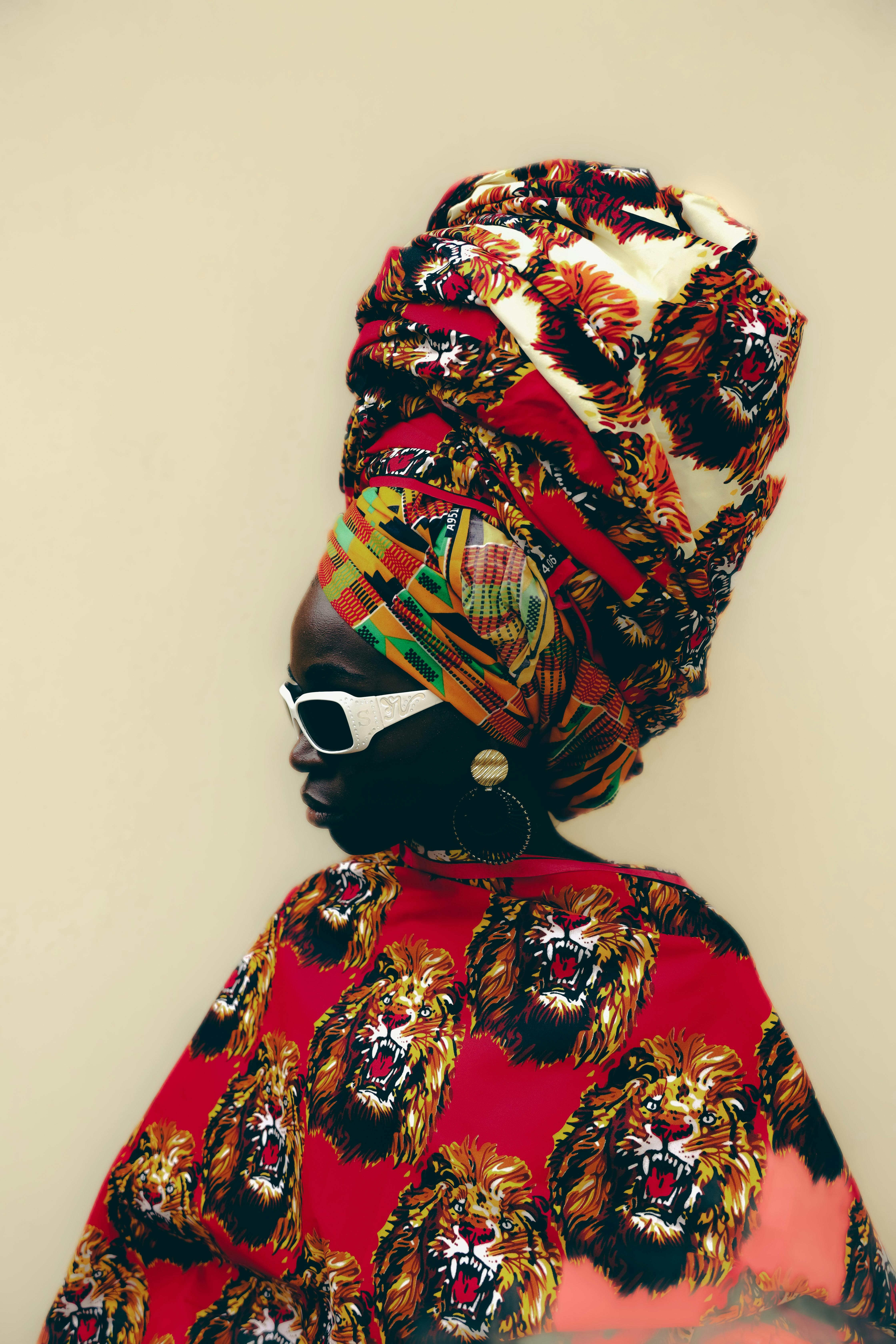 Kostenlos Ein eindrucksvolles Porträt einer Person mit einem farbenfrohen afrikanischen Kopftuch, das einen einzigartigen Stil zur Schau stellt. Stock-Foto