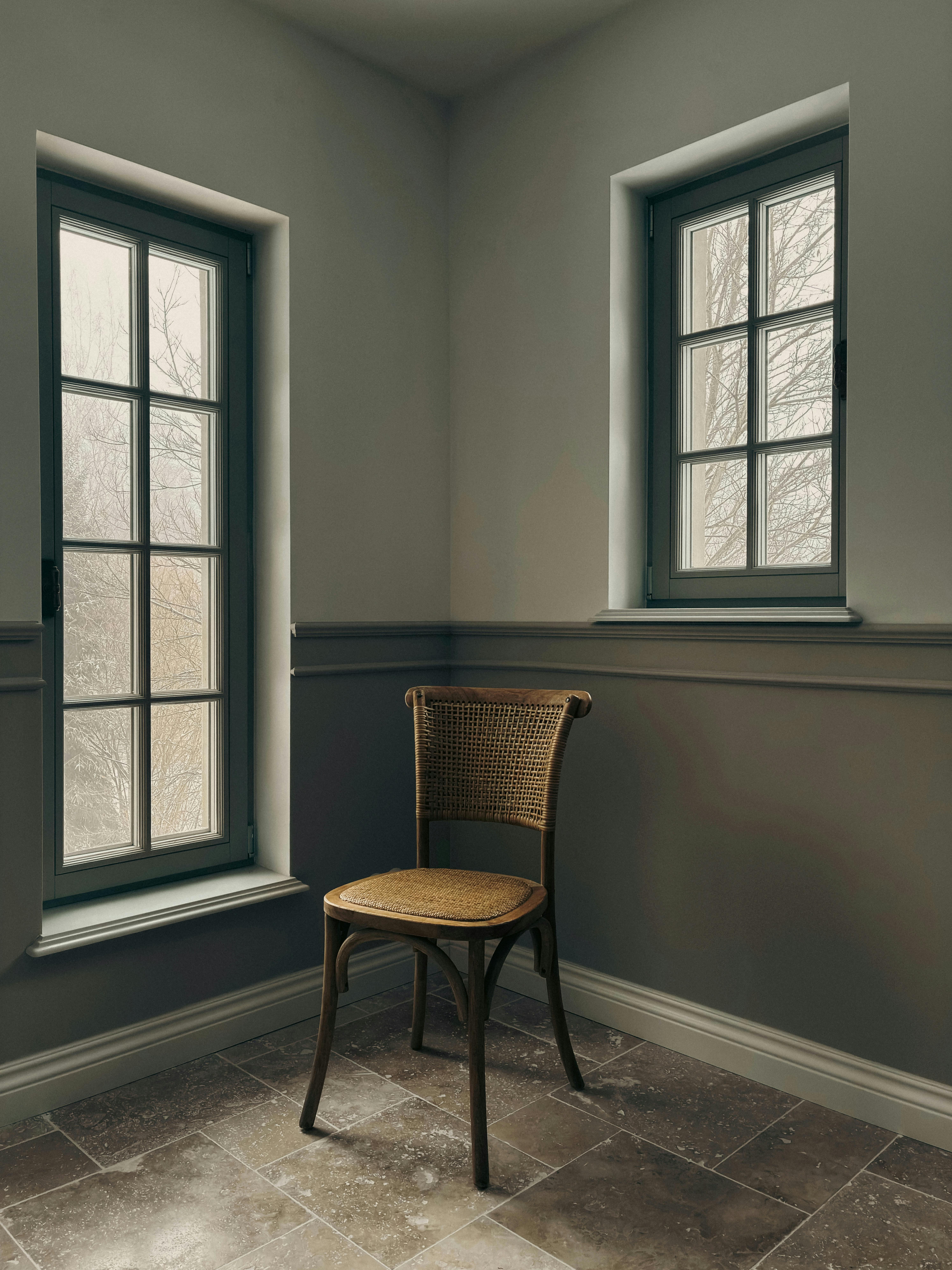 無料 2 つの大きな窓のそばに木製の椅子が置かれた、落ち着いたミニマリストの部屋です。 写真素材