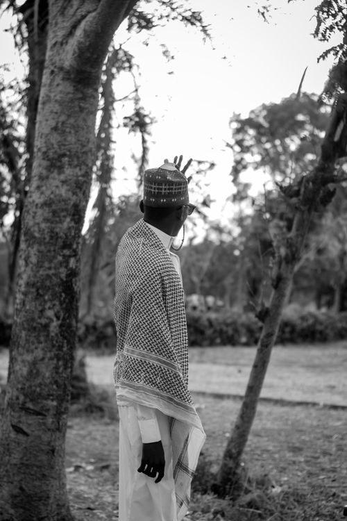 Free Black and white photo of a man in traditional attire looking out into a rural landscape. Stock Photo