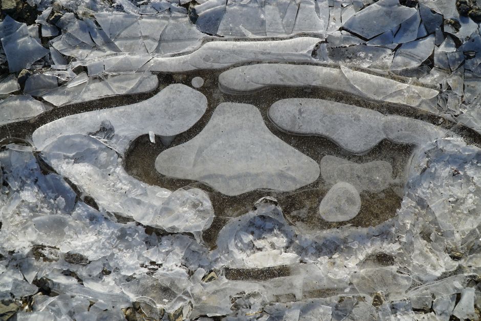 Close-up of cracked ice with unique patterns on a frozen surface.