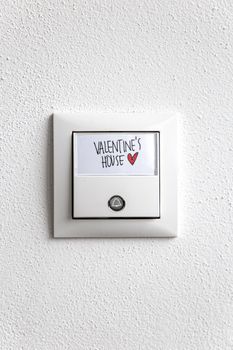 White doorbell with 'Valentine's House' sign and heart symbol adds a quirky touch to home decor.