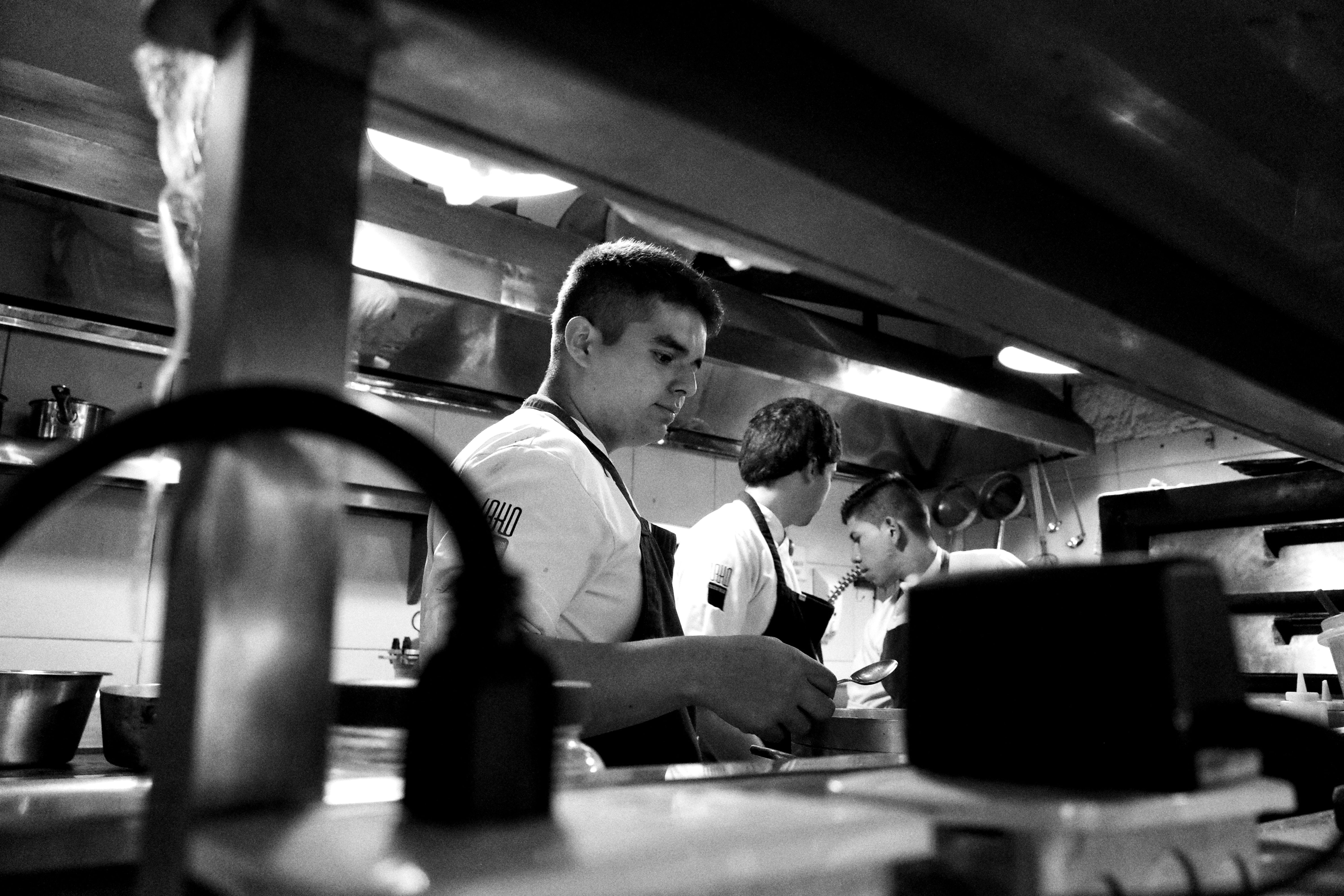 Equipo culinario colaborando en cocina profesional