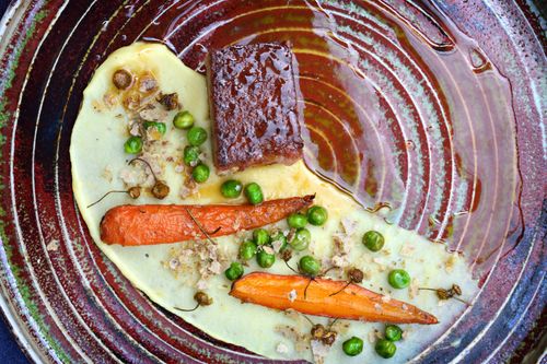 Free Elegant presentation of glazed carrots, peas, and beef on a textured plate. Stock Photo