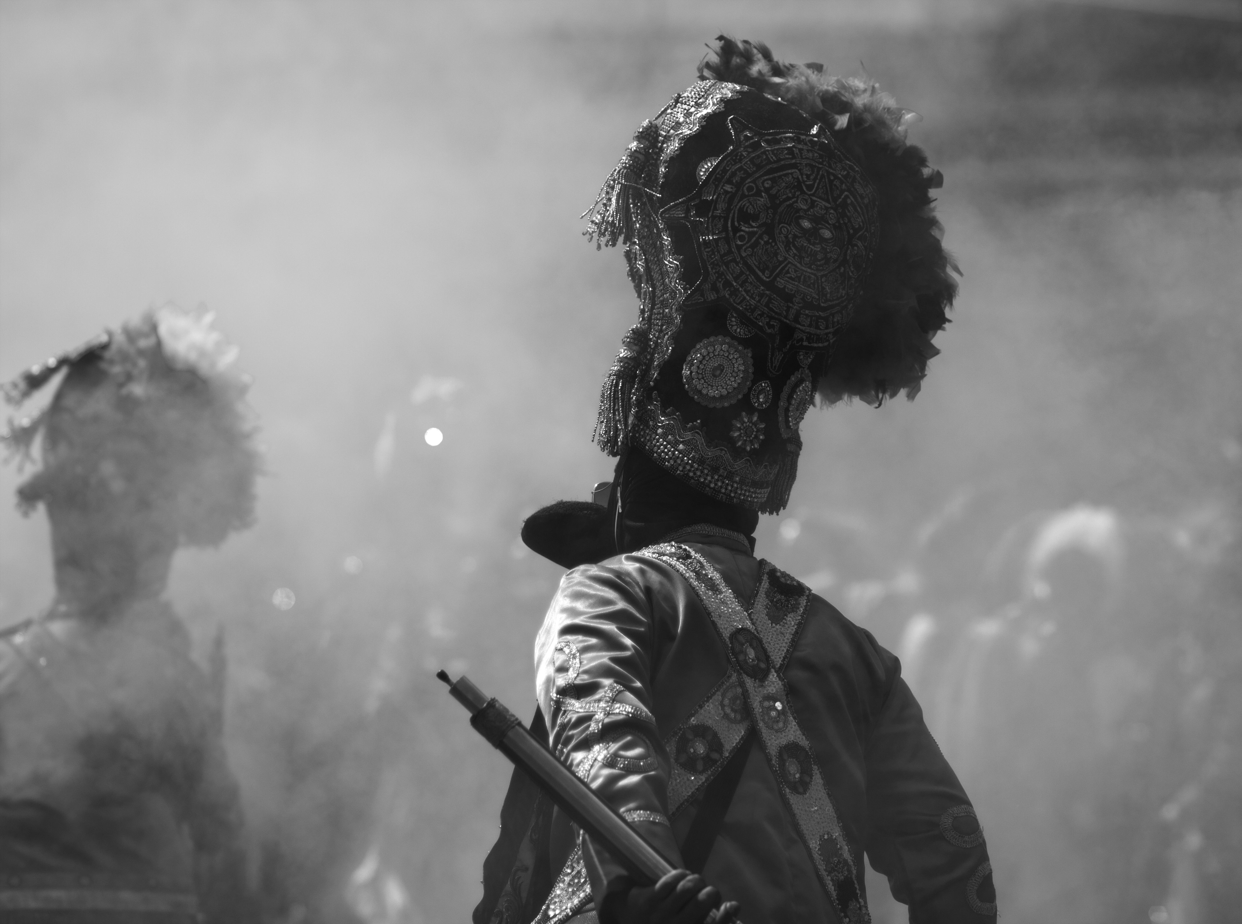 Black and white photo of a Mexican carnival participant in traditional costume at the Huejotzingo festival.
