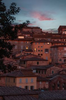 Scenic view of Italian town rooftops at sunset, showcasing rustic charm.