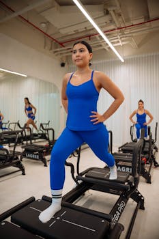 Focused women working out on Lagree machines at a modern fitness studio.