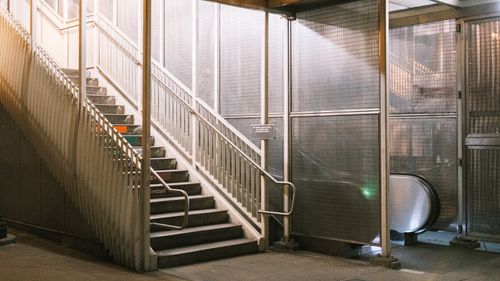 Free A dimly lit urban staircase and escalator entrance in a city station at night. Stock Photo