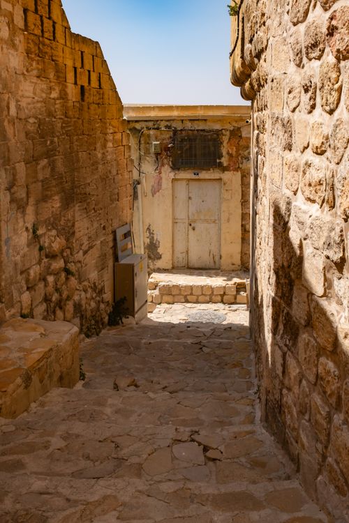 Free Charming sunlit alleyway with stone walls, showcasing rustic architecture. Stock Photo