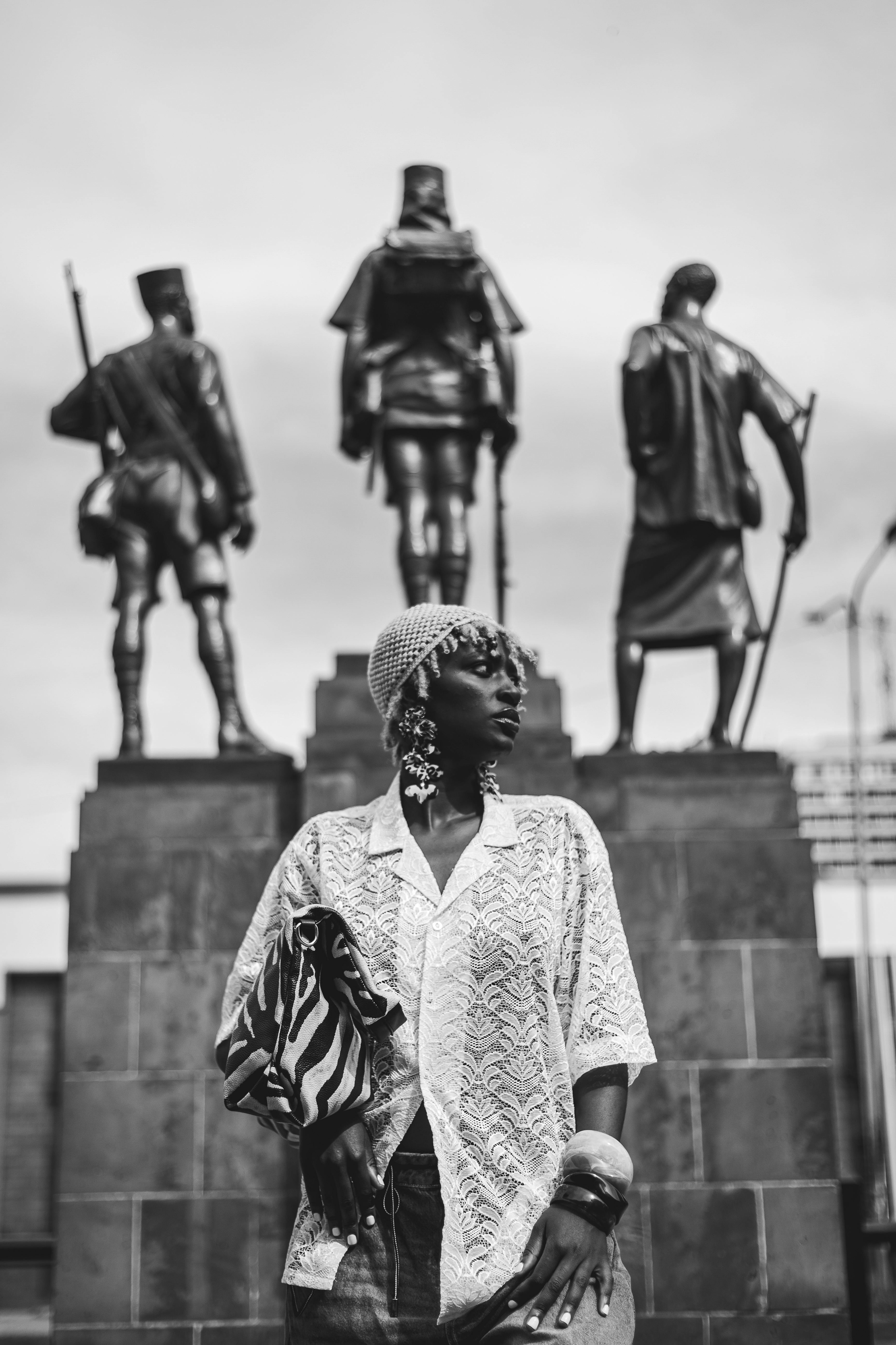 Gratis Seorang wanita bergaya berdiri dengan percaya diri di depan monumen bersejarah di Nairobi, Kenya. Foto Stok