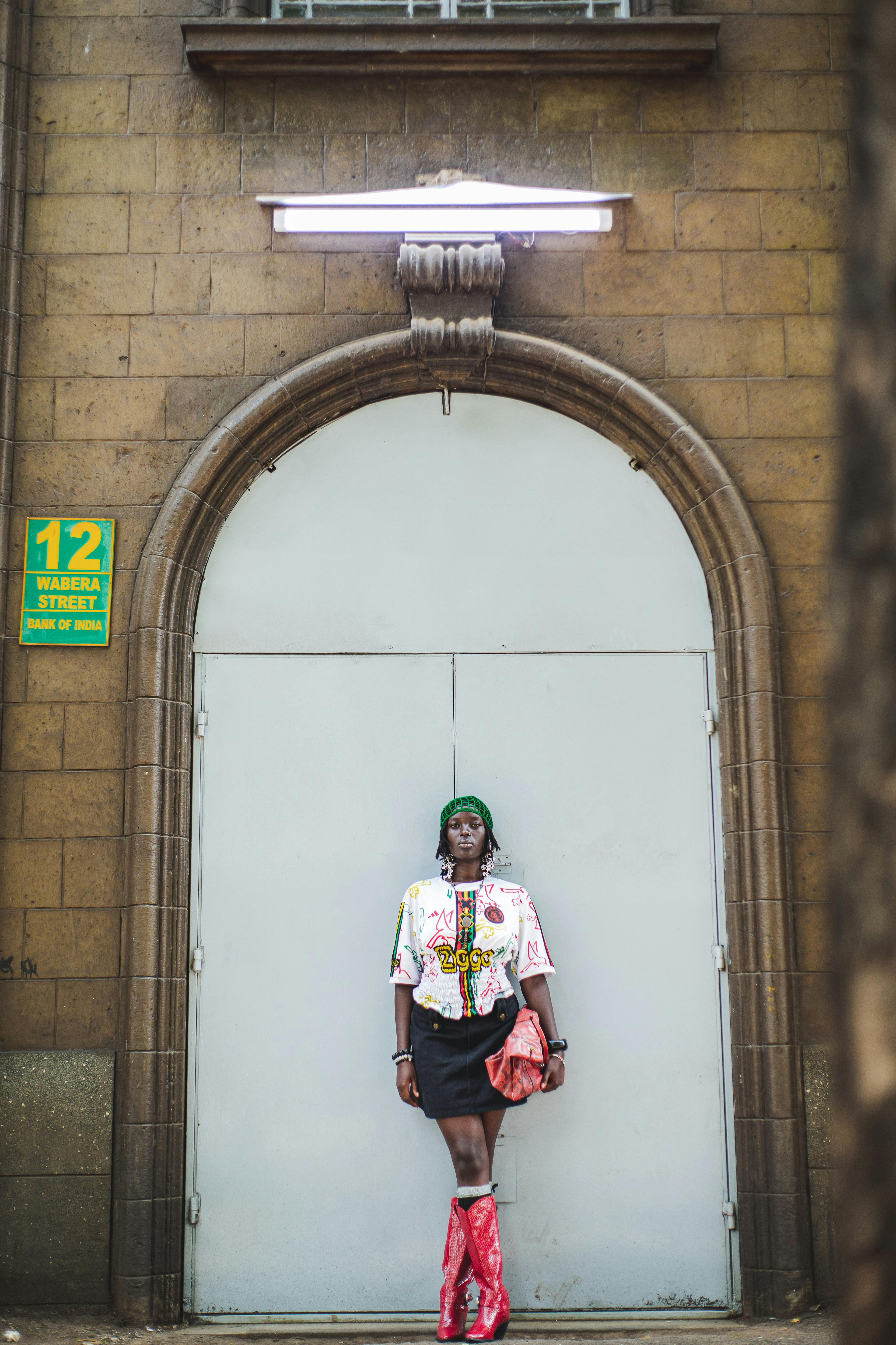 Gratis Seorang individu bergaya berpose dengan pakaian berwarna cerah di tengah latar belakang kota Nairobi, Kenya. Foto Stok