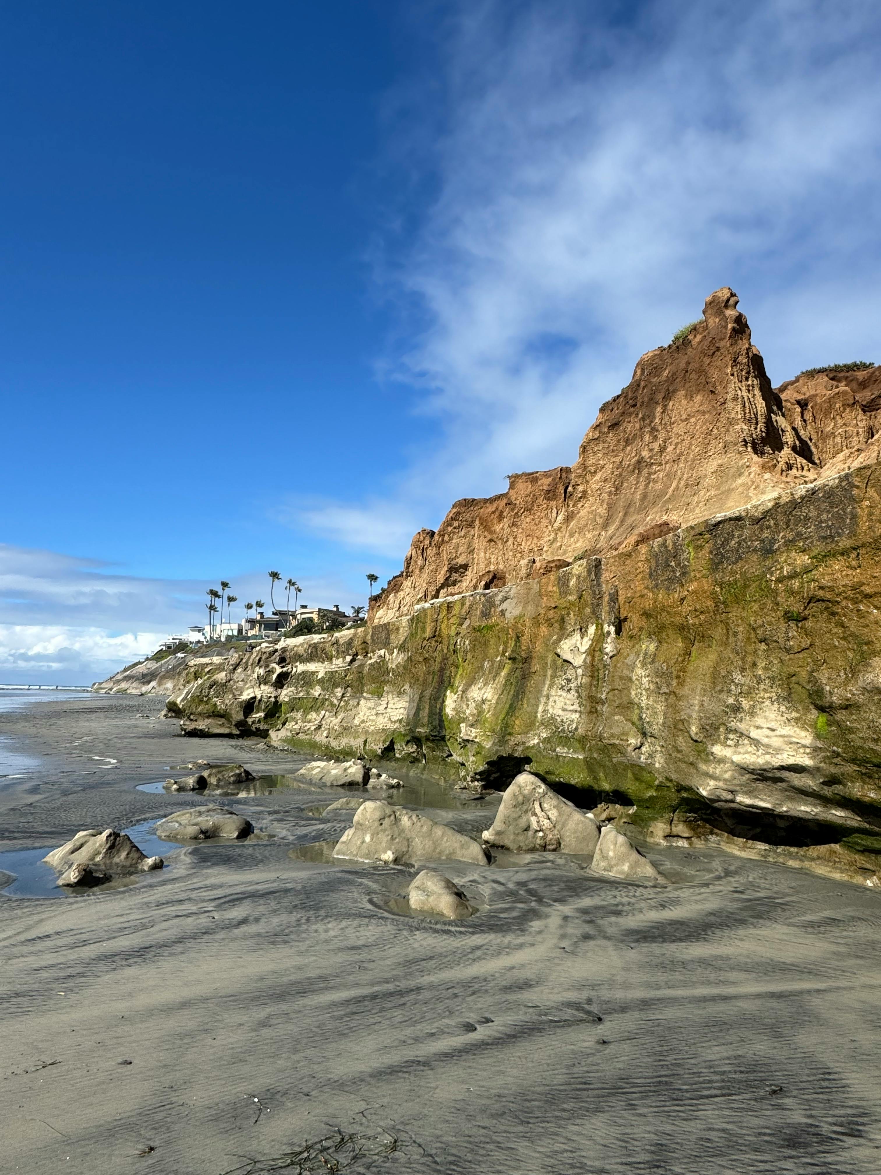 Dramatic cliffs and ocean view at Carlsbad Beach, California under a clear blue sky.
