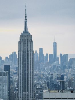 View of the Empire State Building with New York City skyline in the background on a cloudy day.