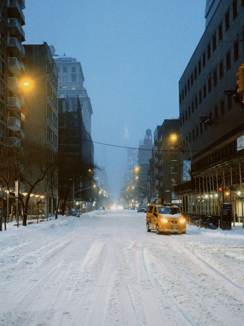 Free Snow-covered street in NYC with yellow taxi and skyscrapers in early morning light. Stock Photo