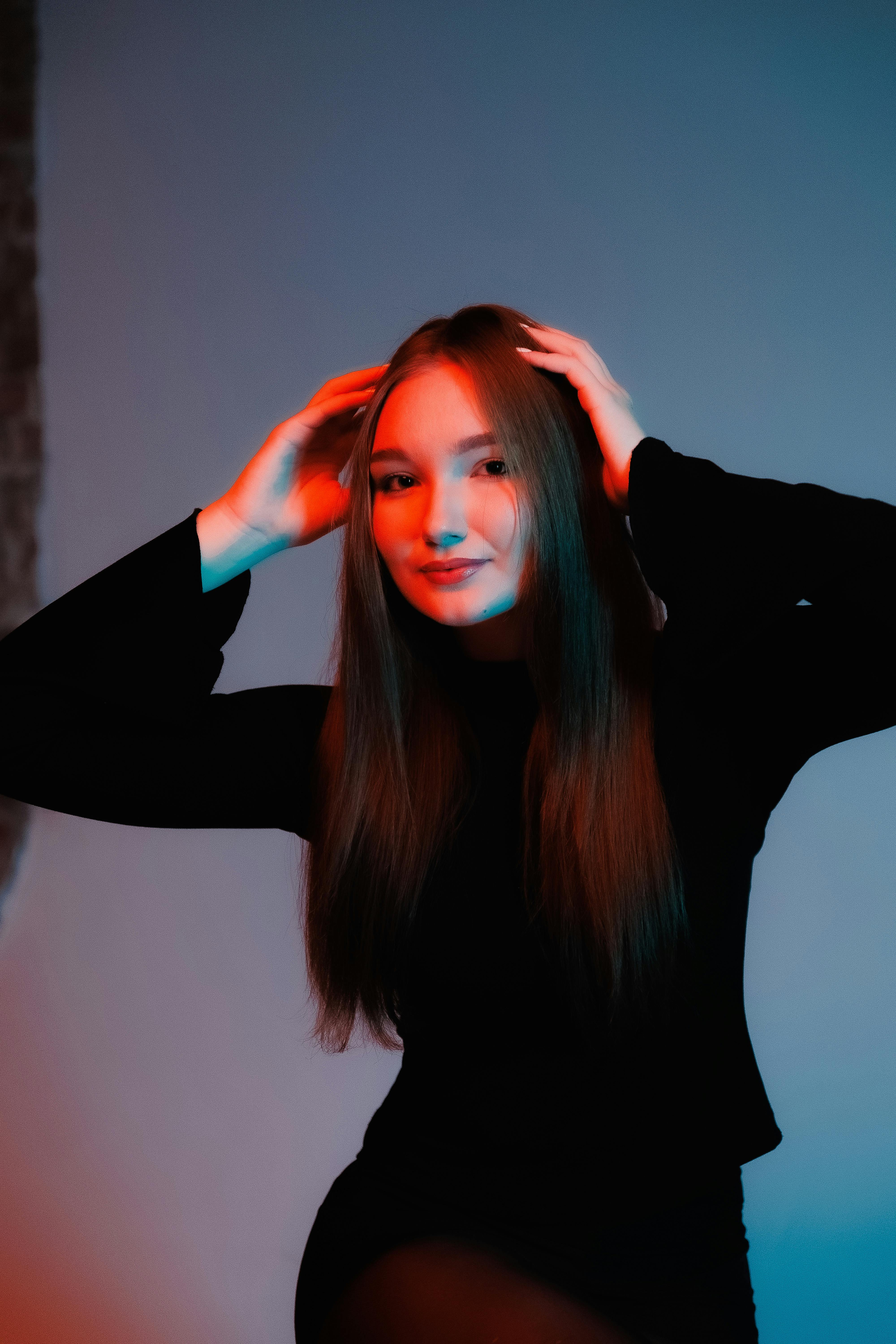 Ücretsiz Stüdyo ortamında canlı kırmızı ve mavi ışıklandırmayla poz veren bir kadının yaratıcı portresi. Stok Fotoğraflar