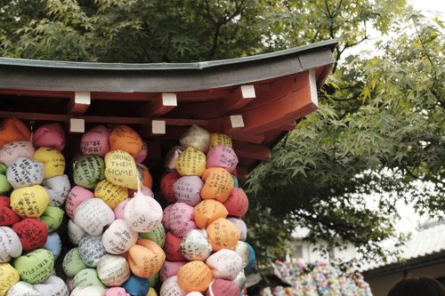 Free Vibrant prayer balls with wishes on them at a Japanese temple, symbolizing hope and cultural tradition. Stock Photo