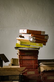 A stack of old books and files in a dimly lit storage room reflects a vintage feel.