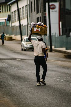 African man carrying fruits in Manzini, Eswatini street, capturing a slice of everyday life.