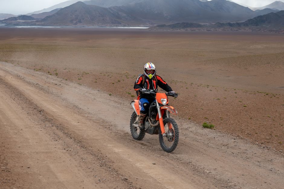 A motorcyclist rides through the stunning desert landscape of Catamarca, Argentina.