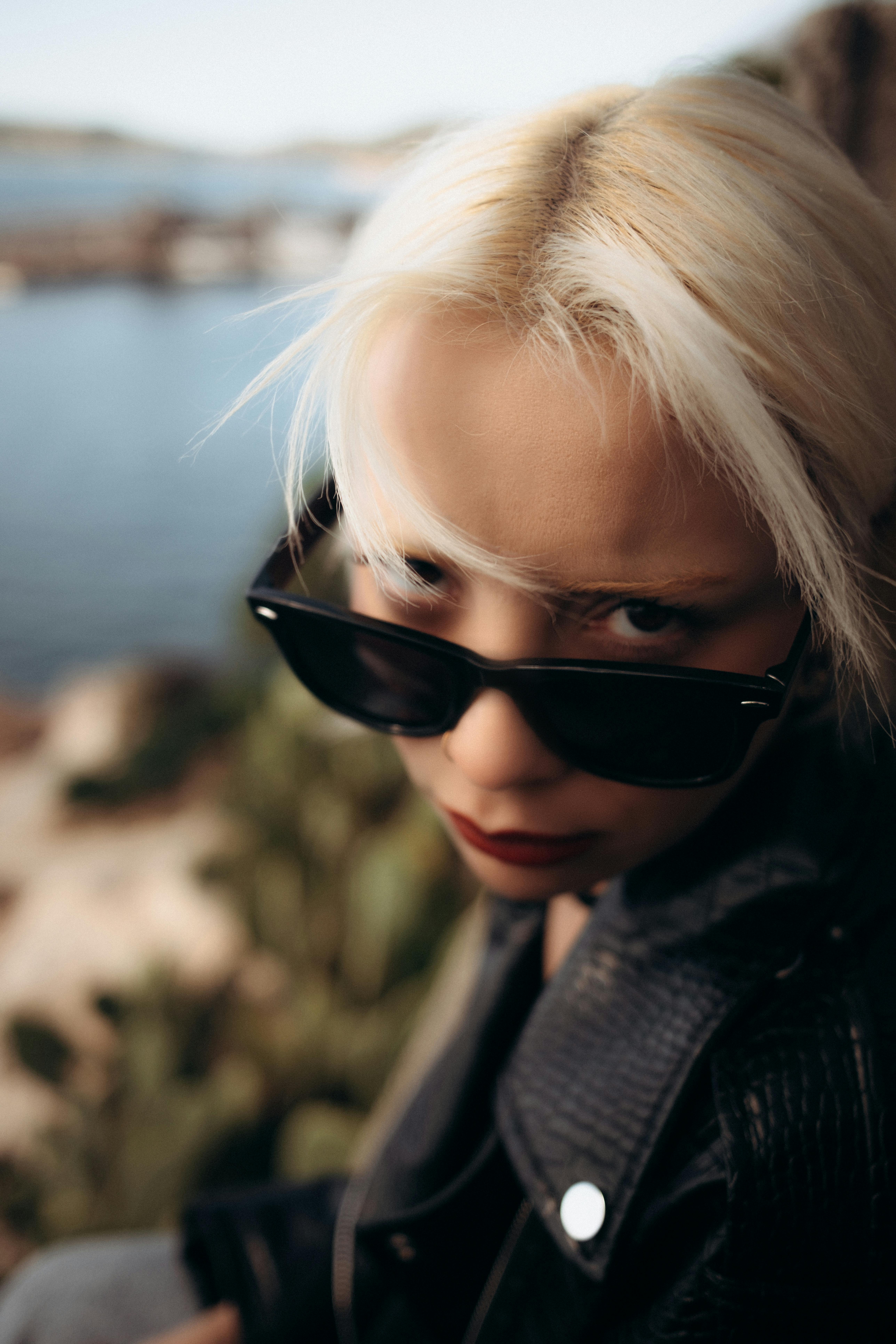 Free Close-up portrait of a young woman wearing sunglasses with a rebellious look. Stock Photo