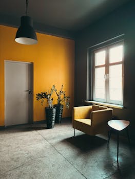Modern minimalist living room with yellow chair, potted plants, and warm lighting.