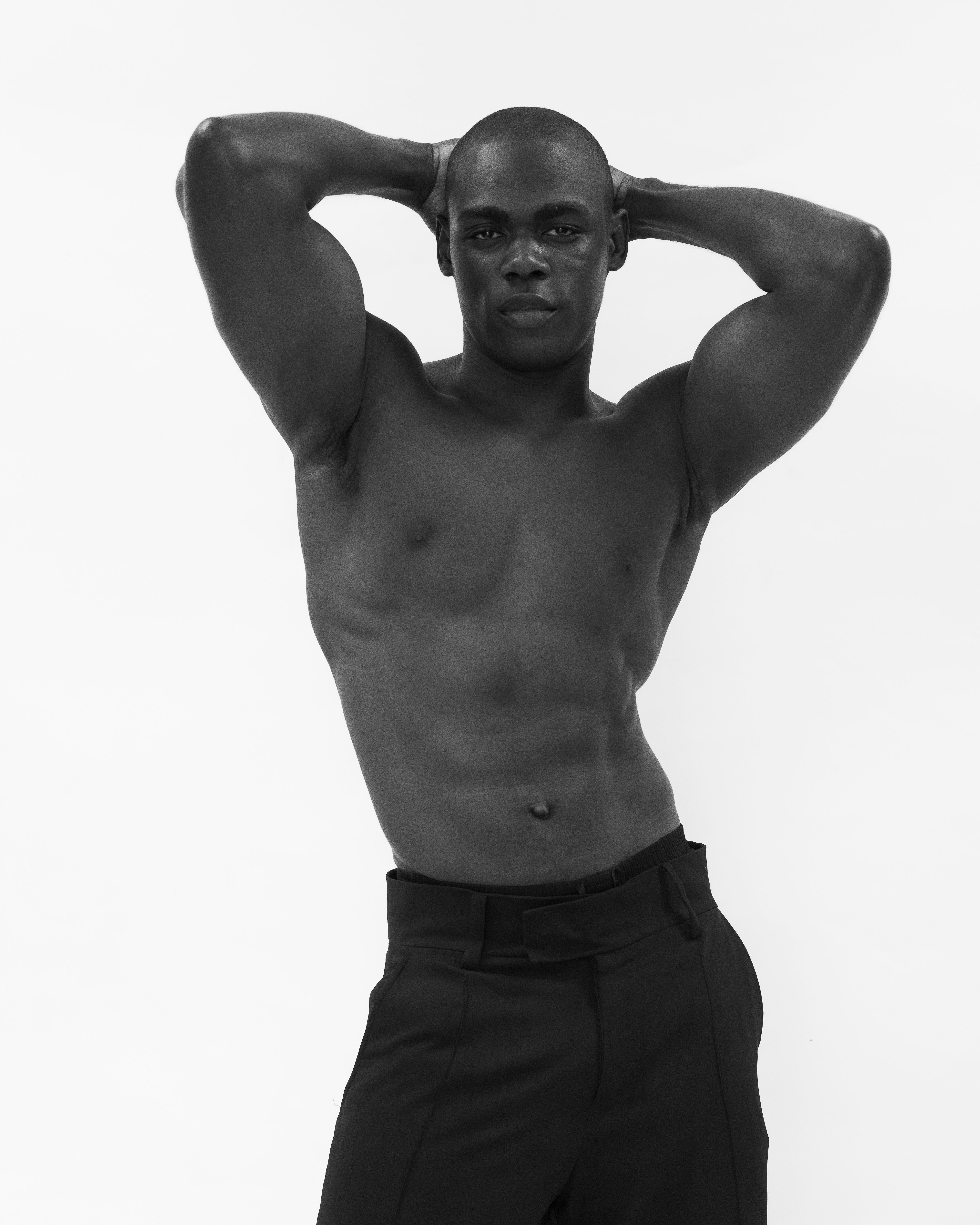 Elegant black and white portrait of an African male model in a fashion pose.