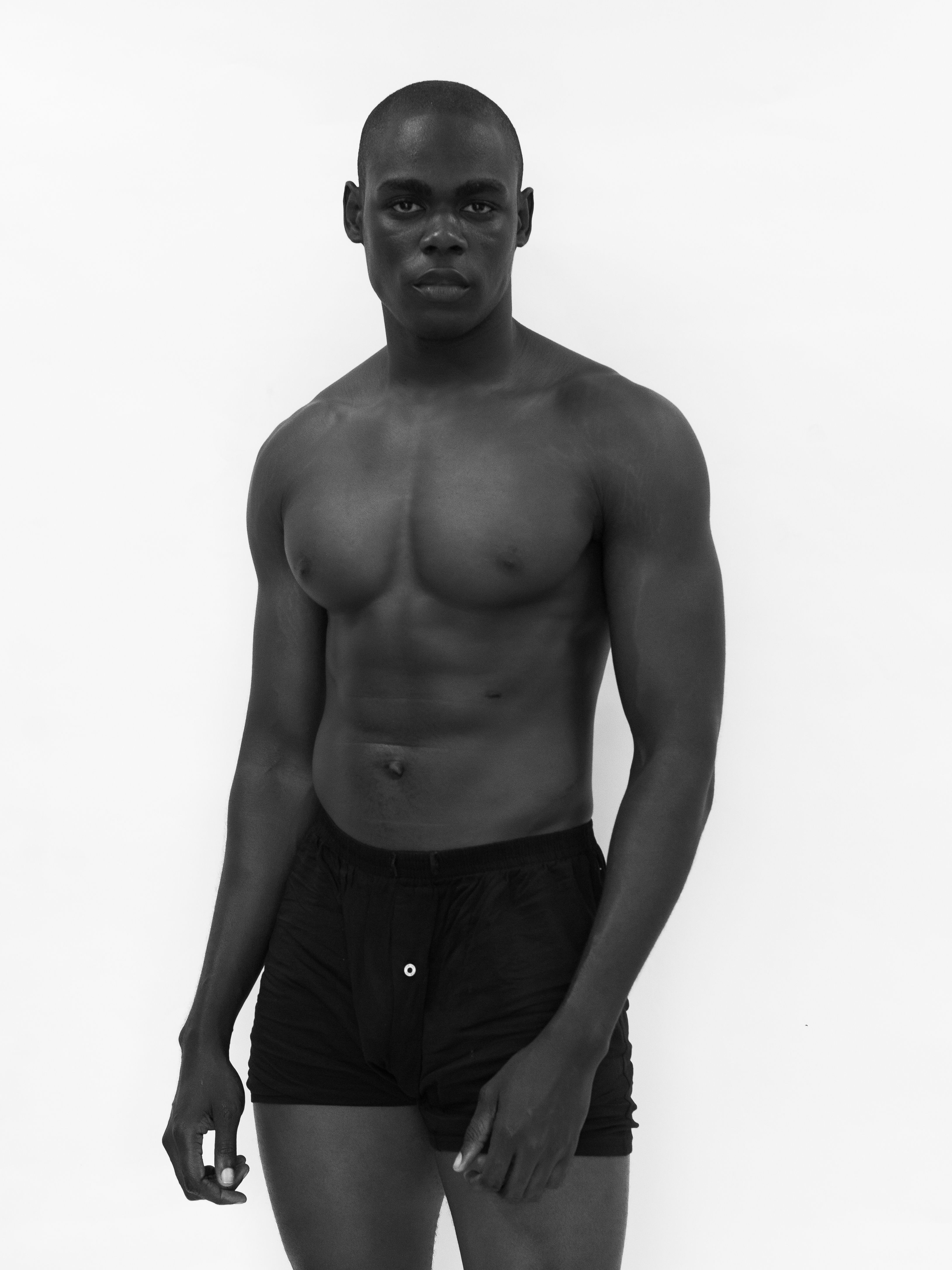 Elegant black and white portrait of a male model showcasing fashion and physique.