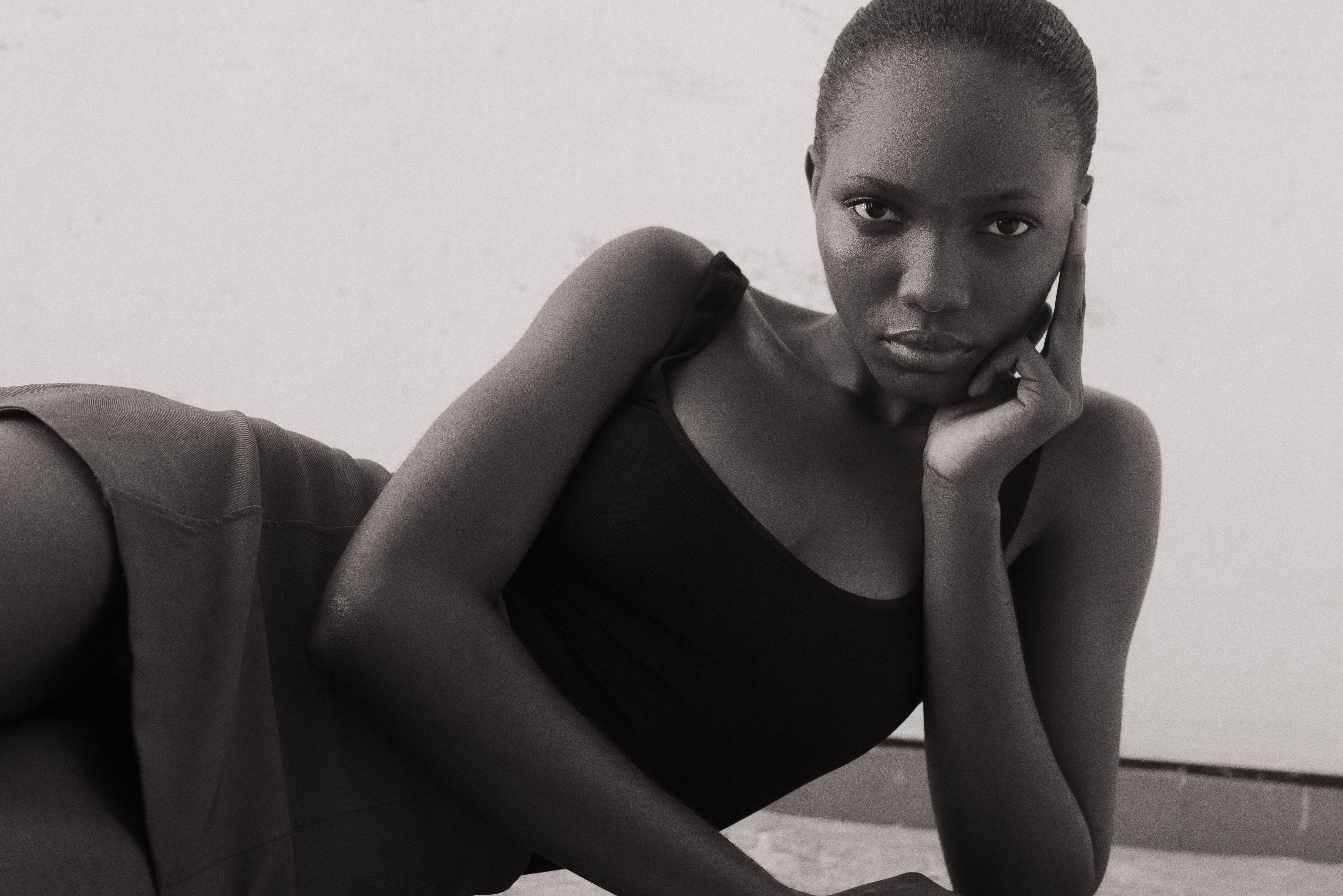 Stylish black and white portrait of an adult female model in a thoughtful pose.