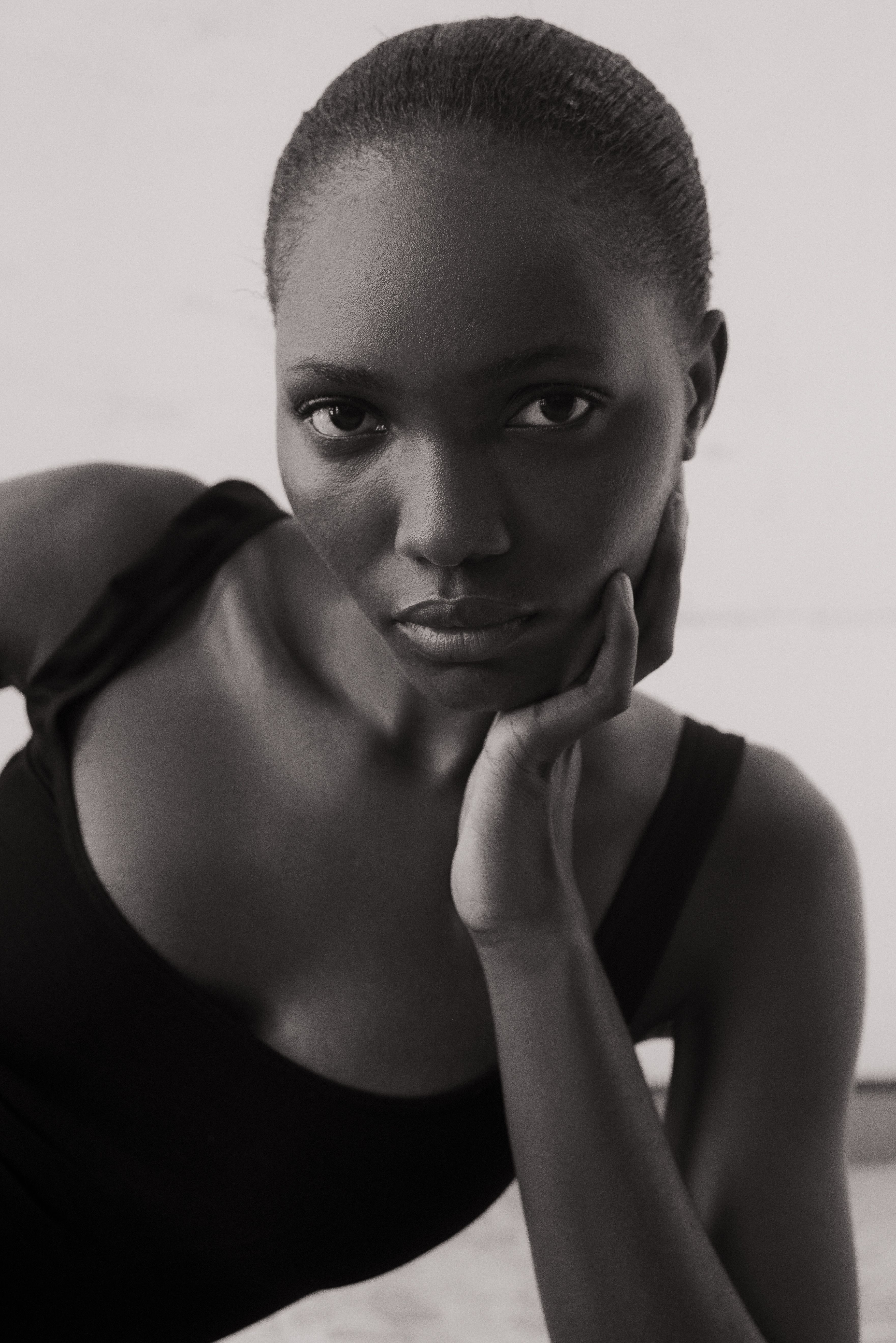 Stunning black and white portrait of a female model posing gracefully indoors.