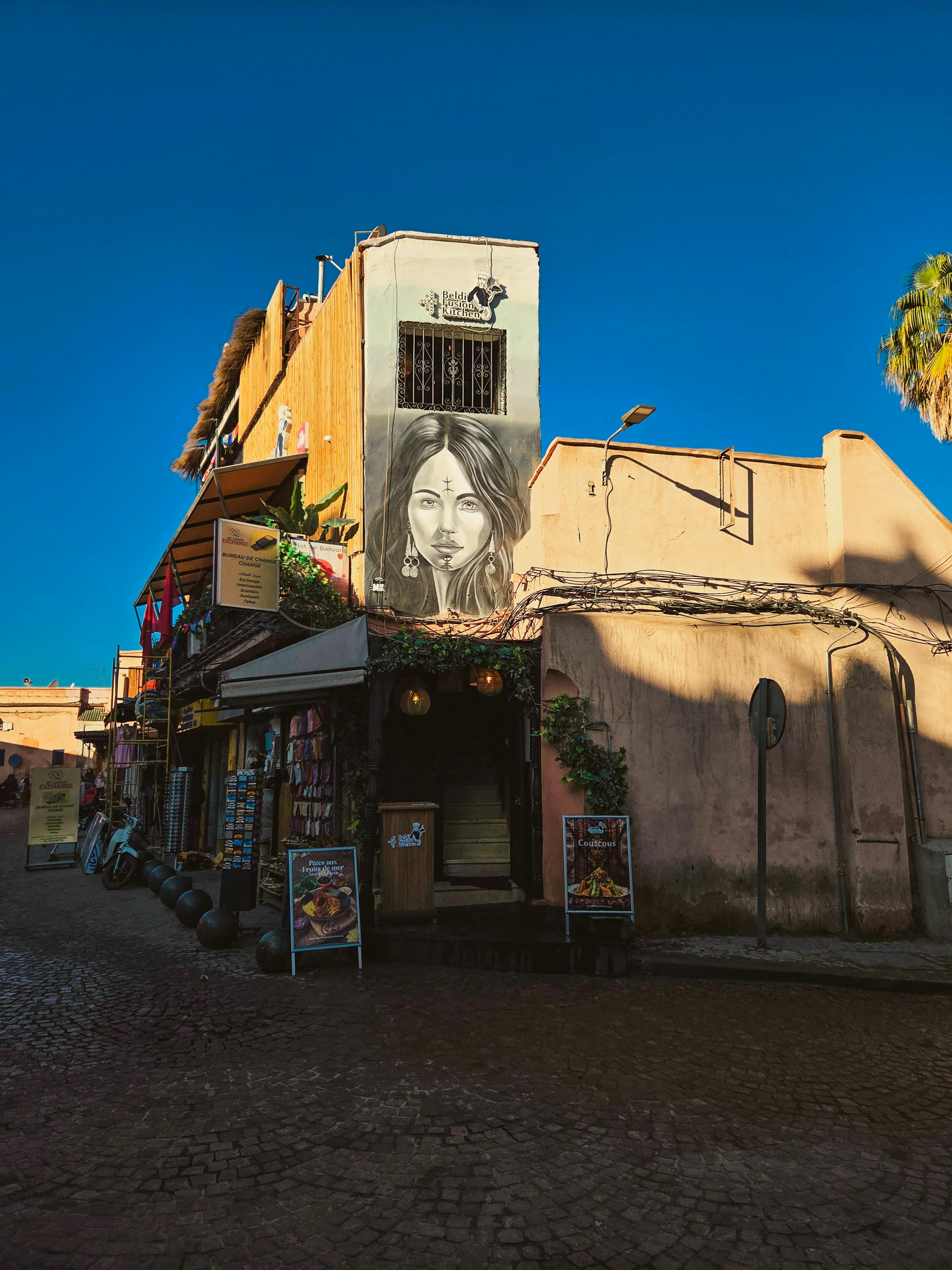 Δωρεάν Σαγηνευτικός δρόμος του Μαρακές με τοιχογραφίες κάτω από έναν καταγάλανο ουρανό. Ζωντανός και πολιτιστικός. Φωτογραφία από στοκ φωτογραφιών