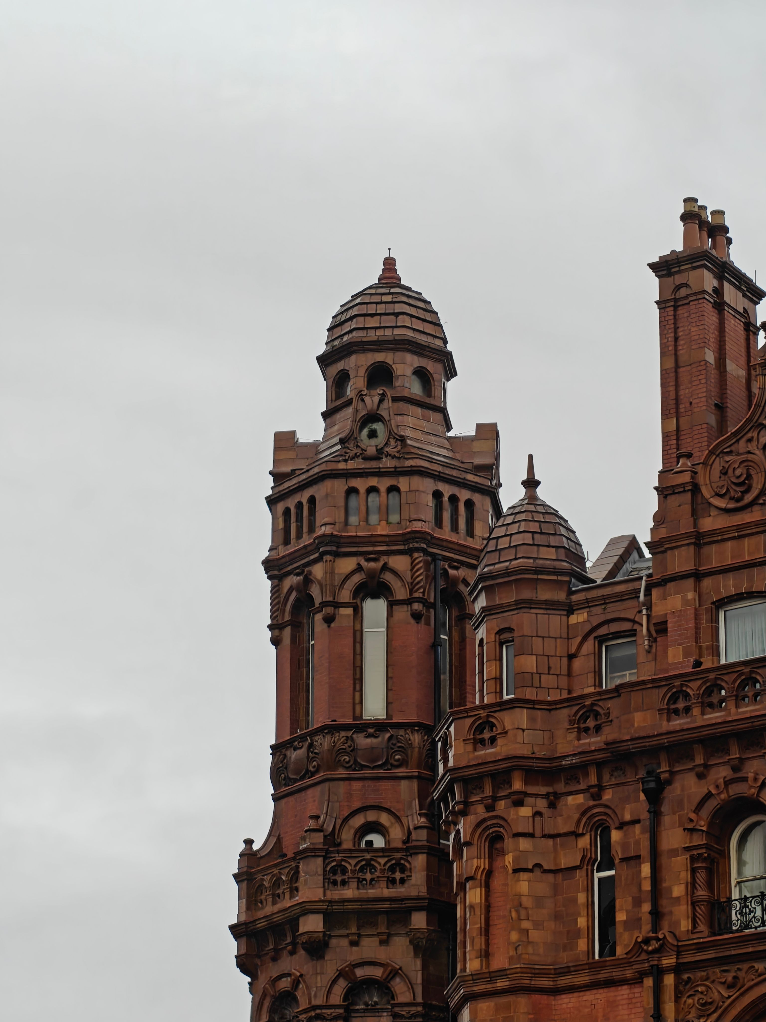 Historic Red Brick Tower Against Cloudy Sky · Free Stock Photo