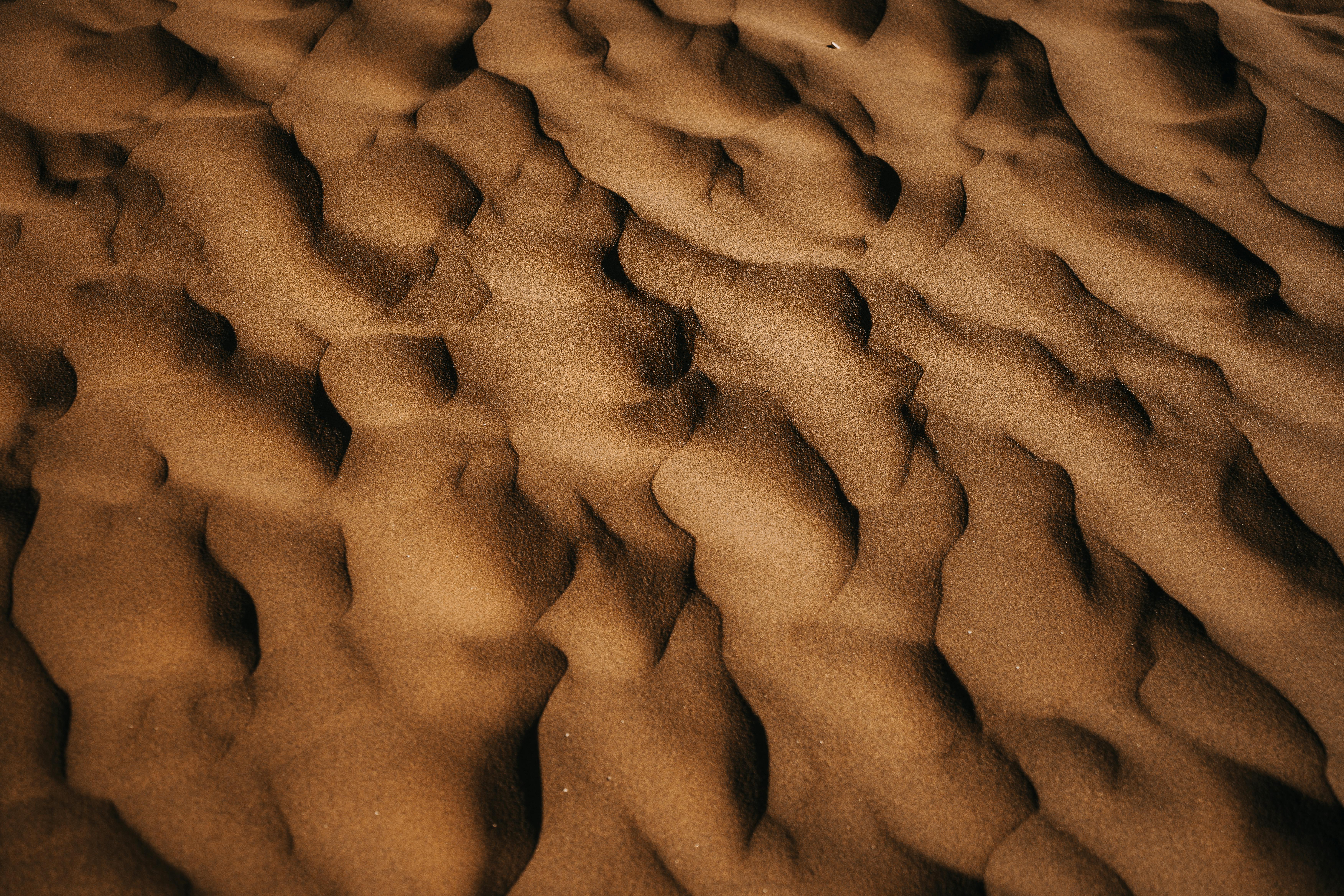 Detailed texture of sand dunes highlighting natural patterns and shapes.