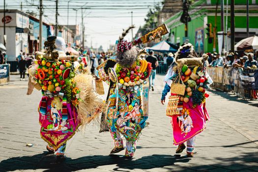 Colorful costumes in a vibrant festival parade in Huejotzingo, Mexico.