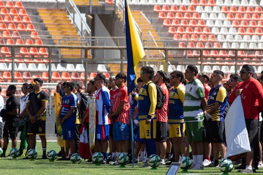 Soccer teams from various backgrounds line up on a sunny stadium field, ready for a match.