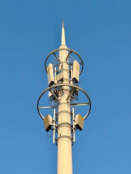 Catch stunning details of a modern cell tower set against a vivid blue sky.