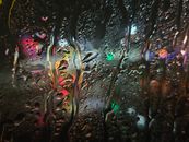 Vibrant city lights seen through raindrops on a window at night in Minneapolis.