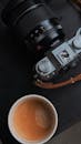 Camera and Coffee on a Dark Surface